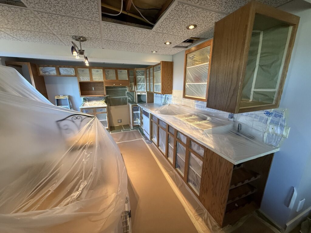 Cabinet painting preparation in a Calgary kitchen — cabinets masked and protected by Renovo Painting Inc