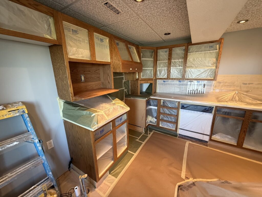 Cabinet painting preparation in a Calgary kitchen — cabinets masked and protected by Renovo Painting Inc
