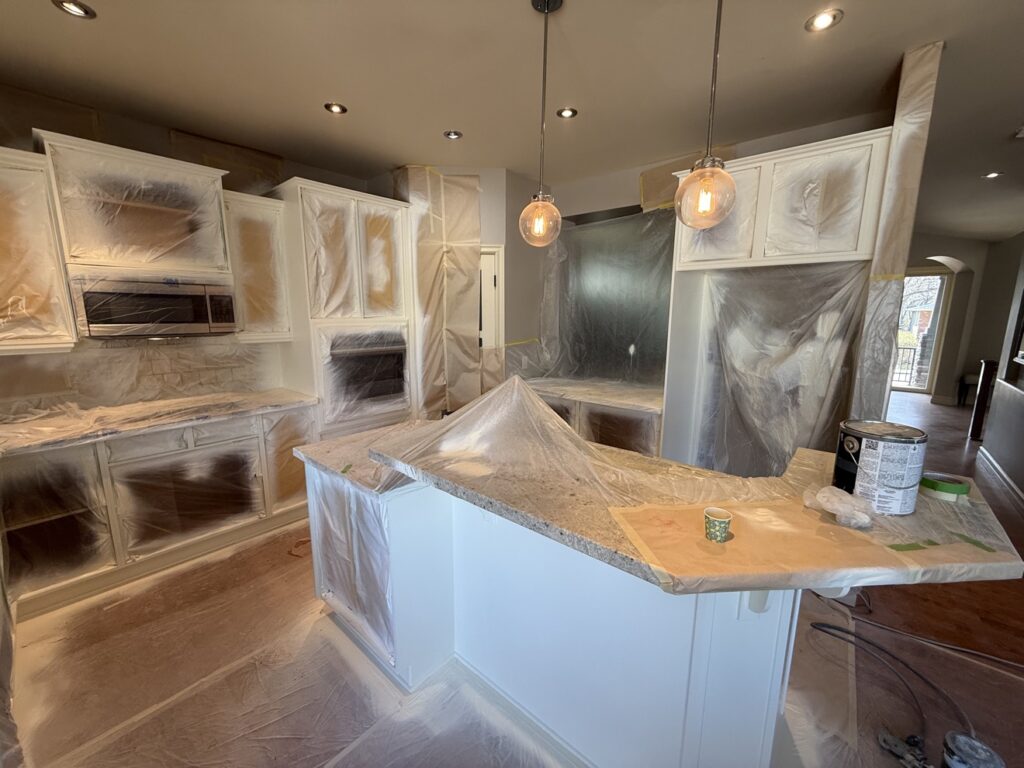 Kitchen cabinet frames being painted white in place by Renovo Painting Inc, Calgary