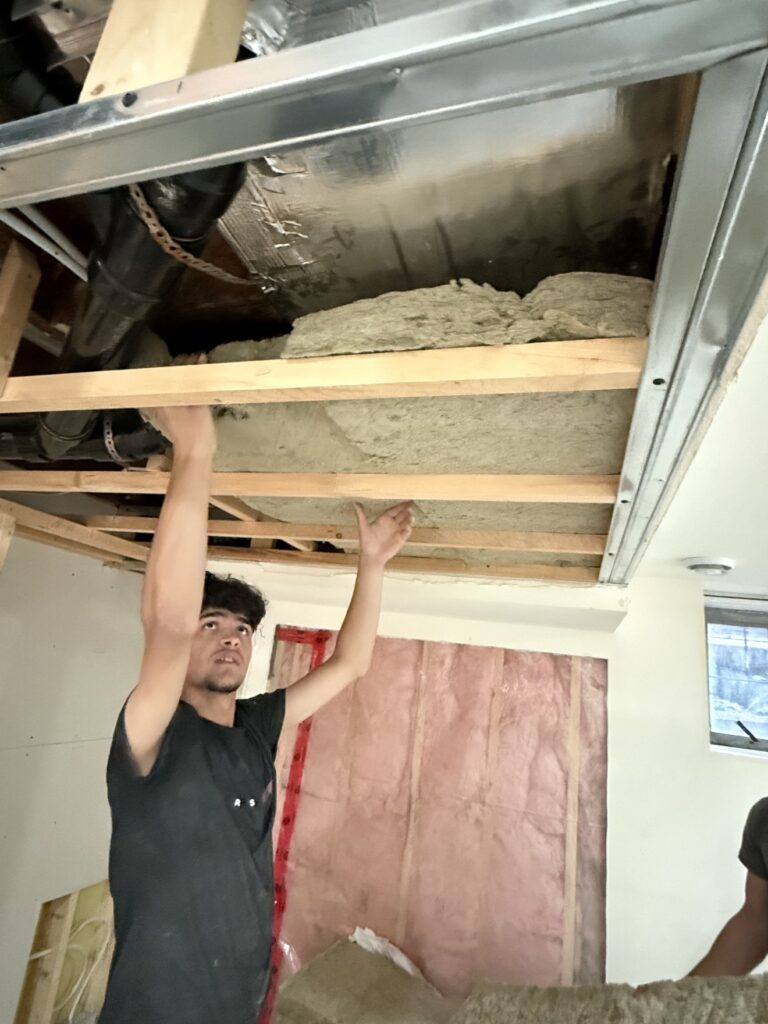 Worker at a ceiling during drywall and painting by Renovo Painting Inc, Calgary