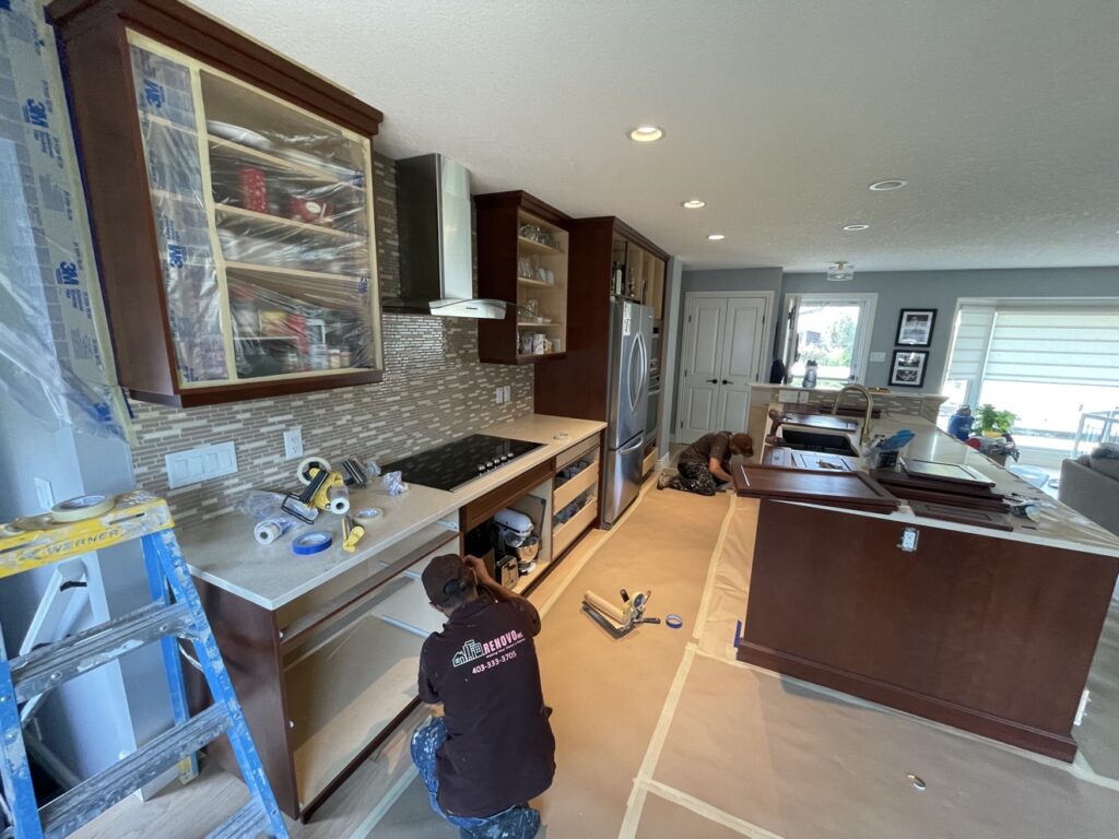 Kitchen before cabinet refinishing — dark wood cabinets prepped by Renovo Painting Inc, Calgary
