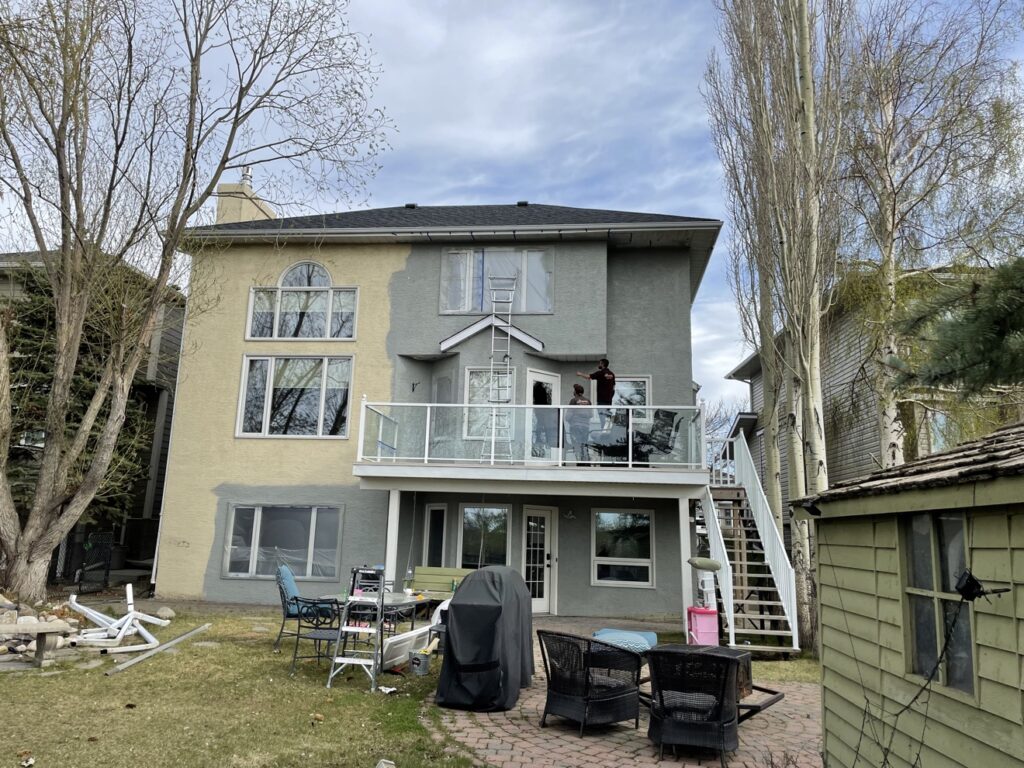 Stucco repaint in progress — old and new colour side by side, Calgary