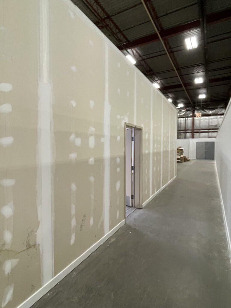 Warehouse walls during painting by Renovo Painting Inc, Calgary